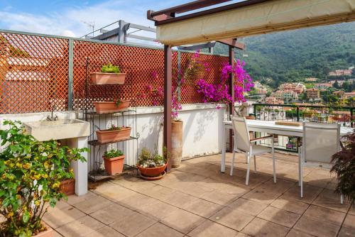 a balcony with a table and a view of the city at Lisa's Stylish Top Floor Flat & Double Pool in Pietra Ligure
