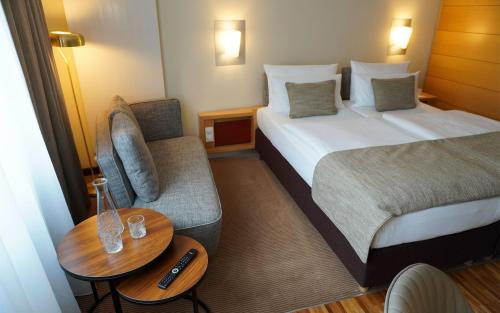 a hotel room with a bed and a chair and a table at centrovital Hotel Berlin in Berlin