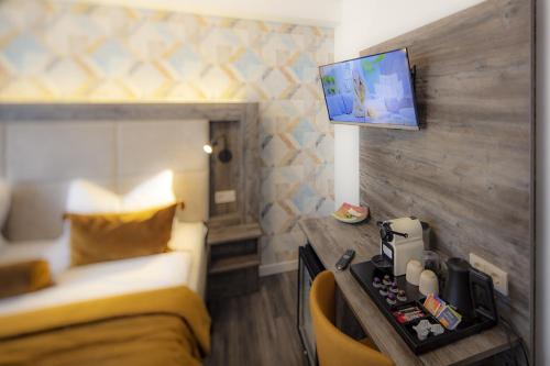 a bedroom with a bed and a tv on a wall at Hotel Zur Feldmühle in Arnsberg