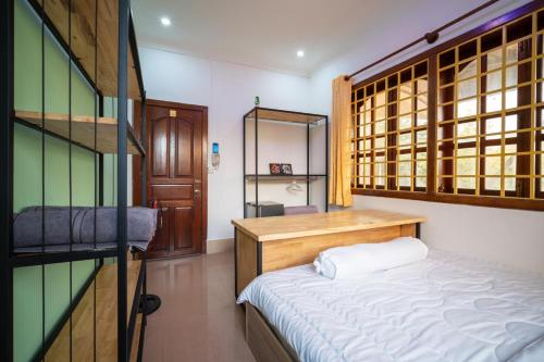 a small room with a bed and a shelf at Teko Paradise and Kitchen in Phumĭ Kruŏs