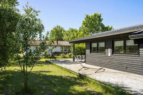 a house with a deck next to a building at Sommerhus tæt på strand i Købingsmark ved Nordborg in Nordborg