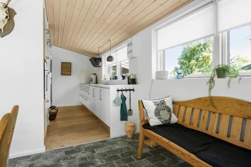 a kitchen with white walls and a wooden bench in a room at Sommerhus tæt på strand i Købingsmark ved Nordborg in Nordborg