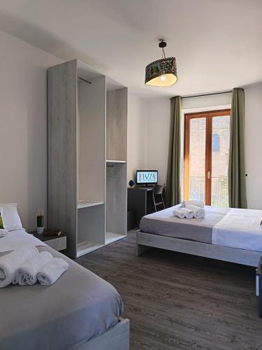 a hotel room with two beds and a television at B&B A' Kiazza in Buompietro