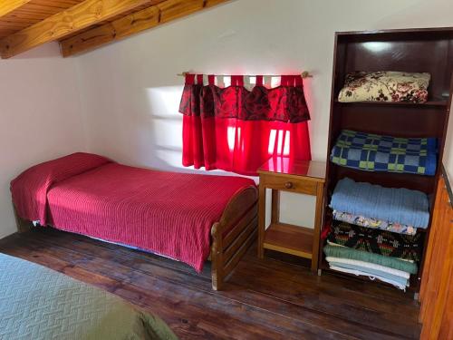 a bedroom with a bed and a desk and a window at Casita Los Samoyedos in Lago Puelo