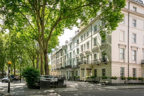 a street in front of a large white building at Hyde Park Apartments - Prime Vision Living London in London