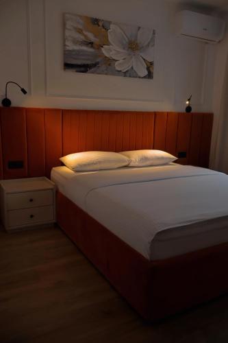 a bed with two pillows and a picture on the wall at Mas Motel in Bosanska Gradiška
