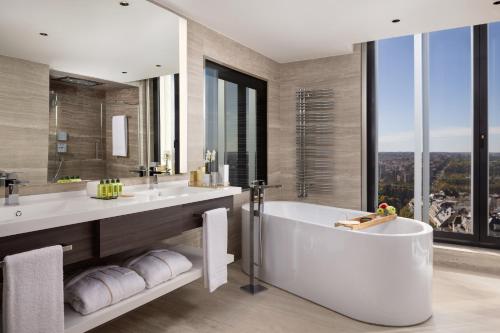 a bathroom with a tub and two sinks and a window at VP Plaza España Design in Madrid