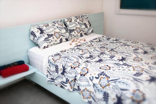 a bedroom with a bed with a blue and white blanket at Appartement Ti Colibri in Rivière-Salée