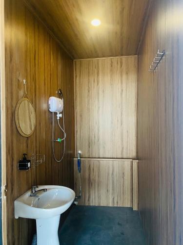 a bathroom with a white sink and a shower at Maison MAY Đà Lạt in Da Lat