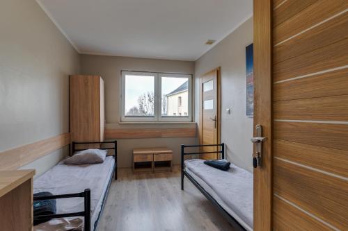 a small room with two beds and a window at Hostel CENTRUM in Radom