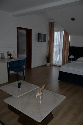 a bedroom with a bed and a desk and a table at Mas Motel in Bosanska Gradiška