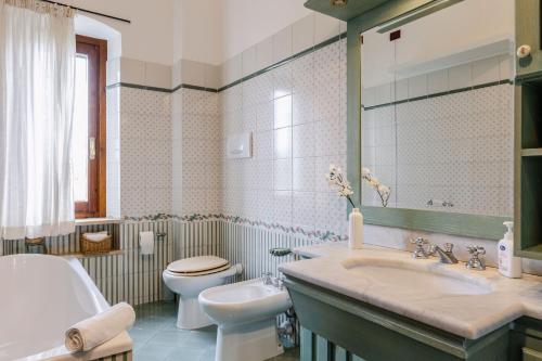 a bathroom with a sink and a toilet and a mirror at Italian Experience-Casa Miramonti in Perugia