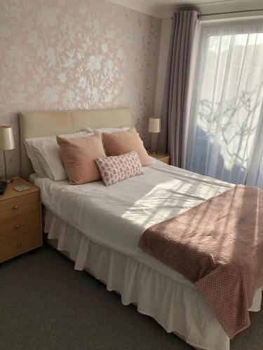 a bedroom with a bed with pillows and a window at Basingstoke En Suite Room in Garden Annex in Basingstoke
