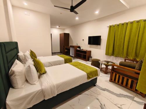a hotel room with two beds and a television at MAHFIL-e-MOTIJHEEL, MOTIJHEEL PARK AND RESORT in Lālbāgh