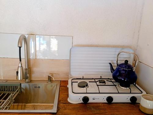 a tea kettle sitting on a stove in a kitchen at La ermita del bosque in Valparaíso