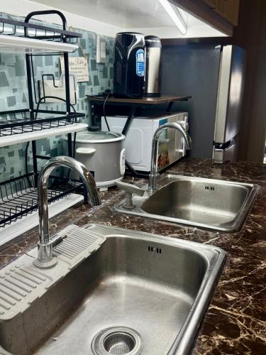 a kitchen sink with two faucets on a counter at 2 Bedroom Condo SMDC Breeze Residences in Manila