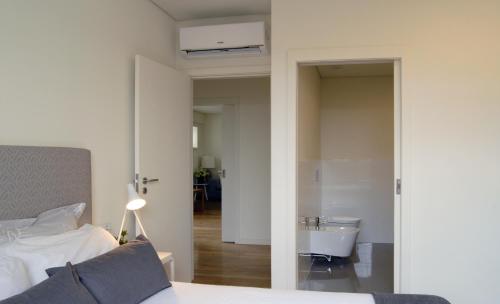 a bedroom with a bed and a bathroom with a tub at Spot Apartments Ceuta in Porto