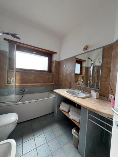 a bathroom with a tub and a sink and a bath tub at Dimora Alta in Olbia