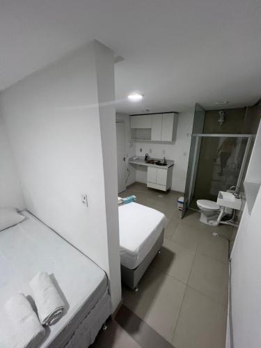 a white room with a bed and a sink at Pousada Pergentino in Maceió