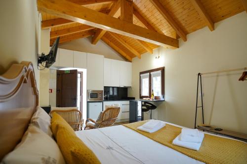 a bedroom with a large bed and a kitchen at Casas da Assureira in Castro Laboreiro