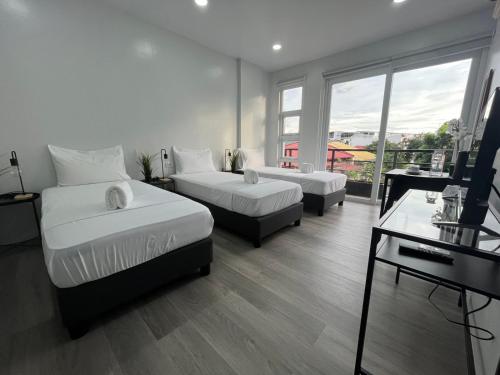 a hotel room with two beds and a window at 20 Boeing Apt in Manila