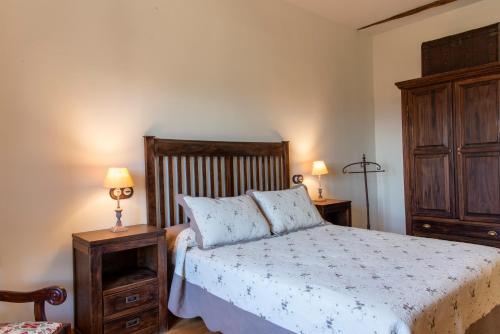 a bedroom with a bed and a dresser and two lamps at La Posada de Maruchi in Pozáldez
