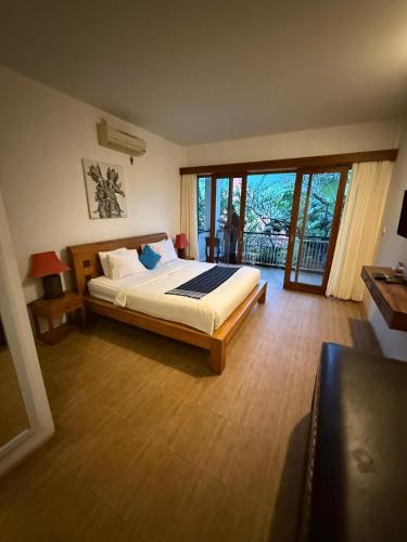 a bedroom with a bed and a large window at The Secreet Garden Hotel in Denpasar