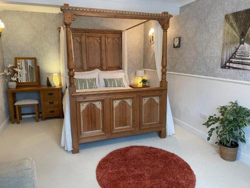a bedroom with a canopy bed with a mirror at Seagulls Boutique Lodgings in Mevagissey