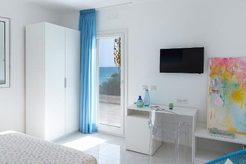 a bedroom with a bed and a desk and a window at Hotiday Room Collection - Torre Lapillo in Torre Lapillo