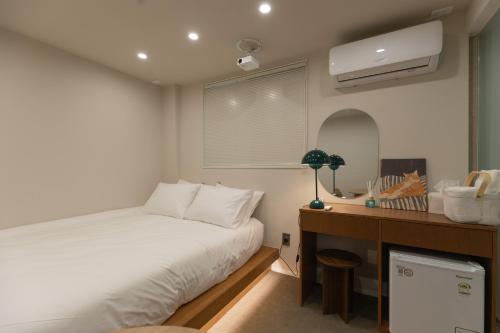 a small bedroom with a bed and a desk at 루아호텔 in Seoul