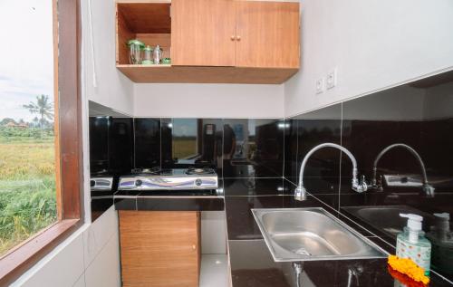 a kitchen with a sink and a counter top at Putra House Ubud in Ubud
