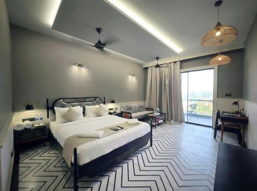 a hotel room with a bed and a large window at Hotel Sonar Bangla Susunia in Kālipahāri