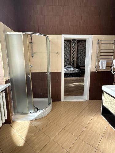 a bathroom with a shower with a glass door at Приватна садиба Фортеця Малехів in Lviv
