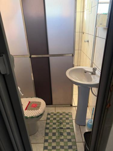 a bathroom with a shower and a toilet and a sink at Pousada da Salete in Campo Mourão