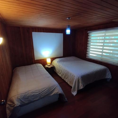 a bedroom with two beds and a large screen at HOSTAL CARHUELLO in Pucón