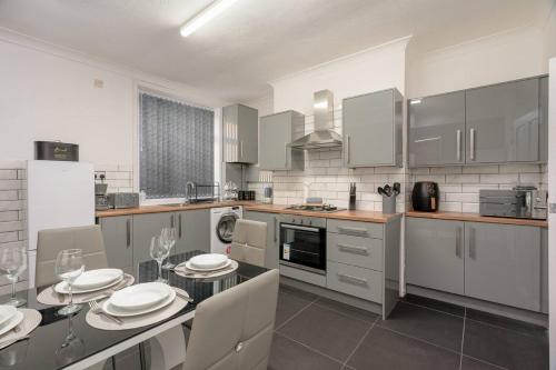 a kitchen with a dining table with plates on it at Family-Friendly 2-Bed Home with Games & Fireplace in Colne