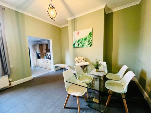 a dining room with a glass table and white chairs at No 7 - 3 Bed House, Parking, Walkable to City, Quiet Location in Sunderland