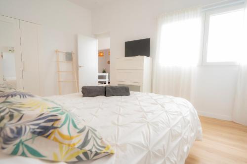 a white bedroom with a large bed with a television at Carlota Cake in Fuencaliente de la Palma