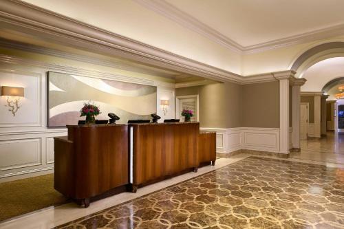 a lobby with a reception desk in a building at Houston Grand Hotel - River Oaks in Houston