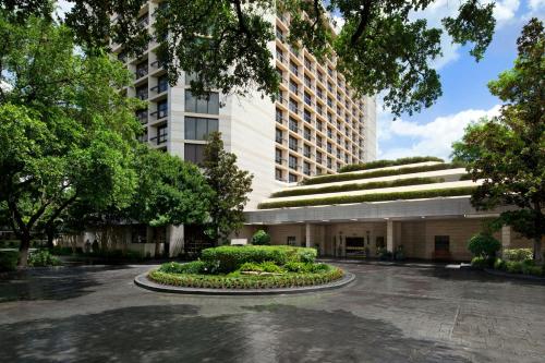 a building with a garden in the middle of a courtyard at Houston Grand Hotel - River Oaks in Houston
