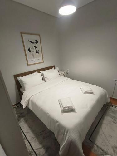 a bedroom with a white bed with two books on it at Stylish Suite in Larisa