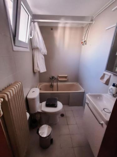 a bathroom with a tub and a toilet and a sink at Stylish Suite in Larisa