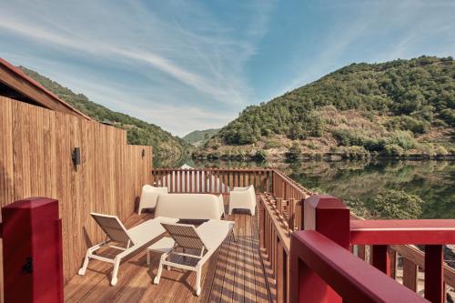 a deck with chairs and a table on the water at Pincelo Nature in Pincelo