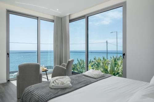 a bedroom with a bed and views of the ocean at OurMadeira - BeachFront in Madalena do Mar