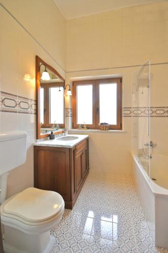 a bathroom with a toilet and a sink and a tub at Bamboo Garden Oasis with Pool in Pula