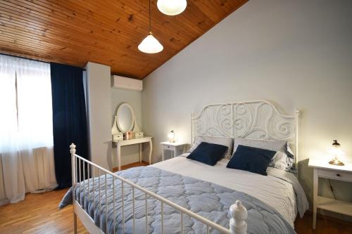 a bedroom with a large white bed with blue pillows at Bamboo Garden Oasis with Pool in Pula