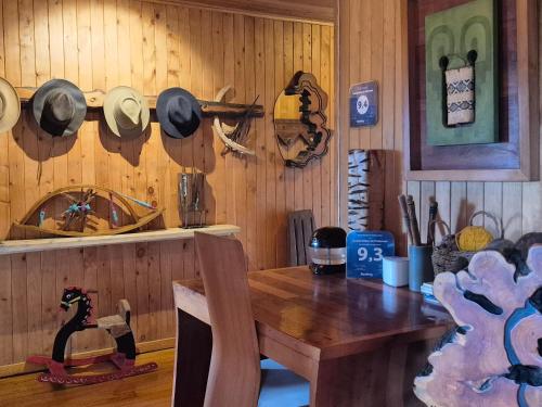 a dining room with a wooden table and hats on the wall at Hostal Boutique El Vergel Azul in Castro