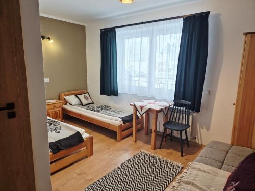a room with a bed and a table and a window at Daglezja in Przyborów