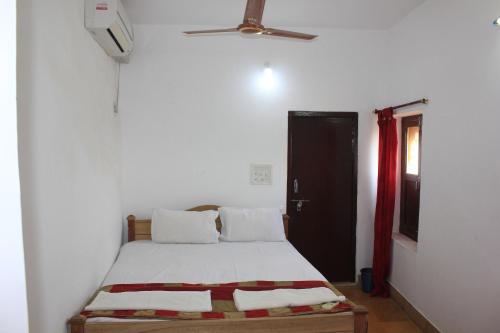 a bedroom with a bed and a ceiling fan at Mud Mirror Guesthouse in Jaisalmer