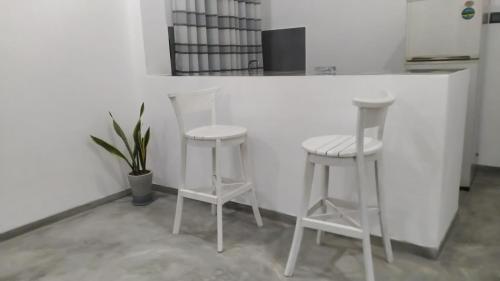 two white stools sitting at a counter in a kitchen at Villa C & C Thalpe in Talpe
